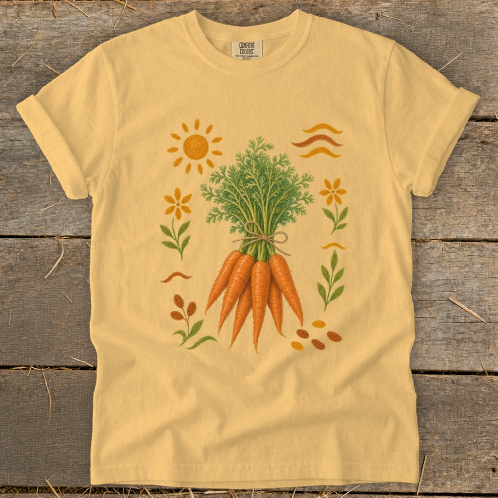 Yellow t-shirt featuring a whimsical carrot harvest illustration with sun, flowers, and leaves.