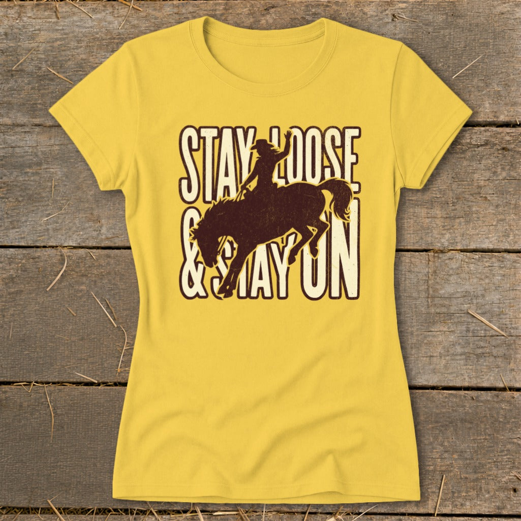Yellow t-shirt with distressed brown graphic of a rodeo rider and text "STAY LOOSE & STAY ON".