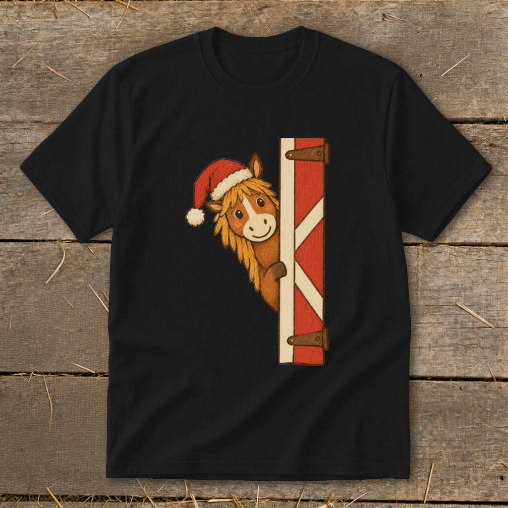 Black t-shirt with a cartoon horse wearing a Santa hat peeking from a red barn door.