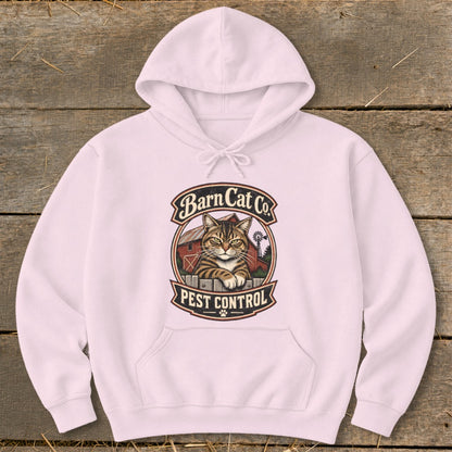 A light pink hooded sweatshirt features a vintage graphic of a tabby cat behind a fence with the text Barn Cat Co. Pest Control.