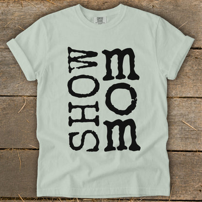 Light green t-shirt with black "MOM" text vertically aligned in two columns.