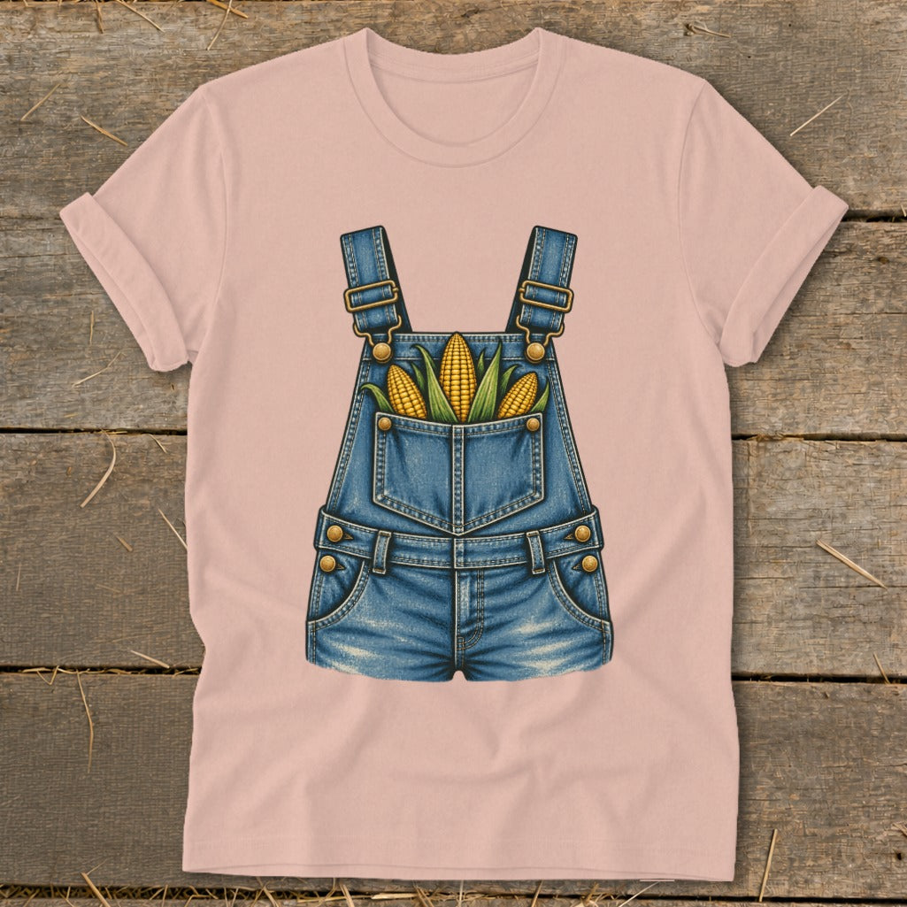 Pink t-shirt with a graphic of denim overalls filled with corn.