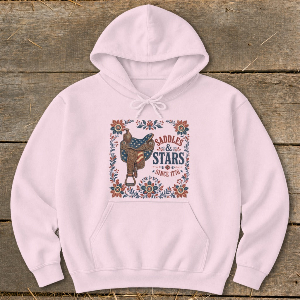 Pink hoodie with "Saddles & Stars Since 1776" text and western saddle graphic.