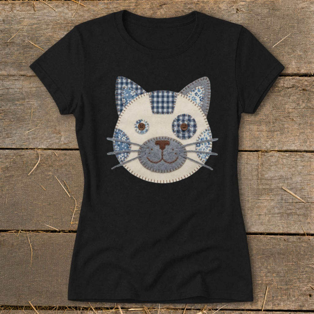 Black t-shirt with a fabric applique cat face featuring blue and white patterns.