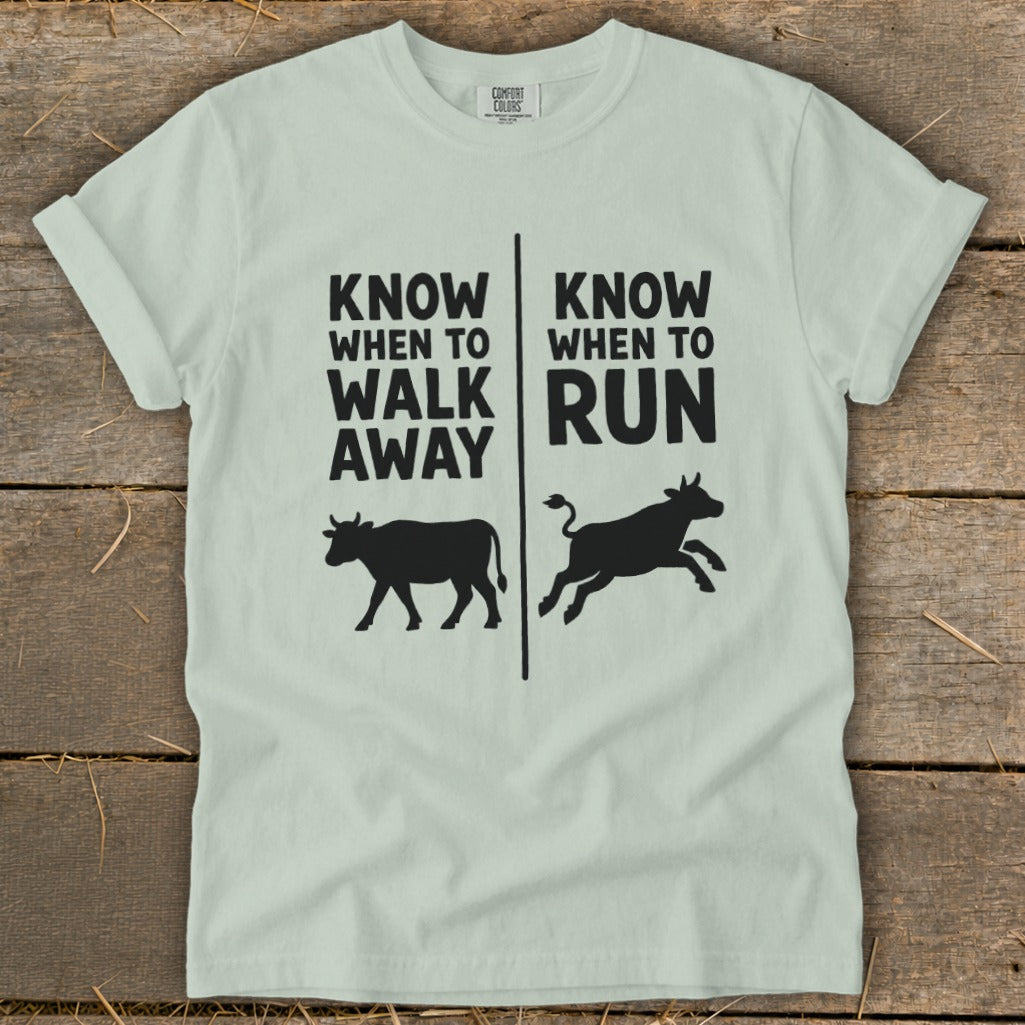 Light green t-shirt with black text and cow graphics reading "Know When to Walk Away" and "Know When to Run".