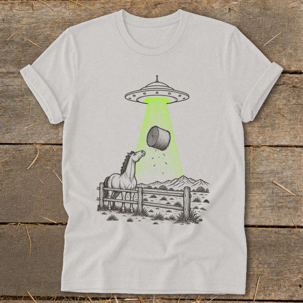 UFO beaming a hay bale from a horse in a fenced pasture.