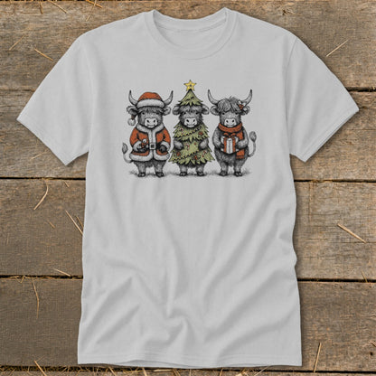 Three highland cows in festive attire, one dressed as Santa, one as a Christmas tree, one holding a gift.