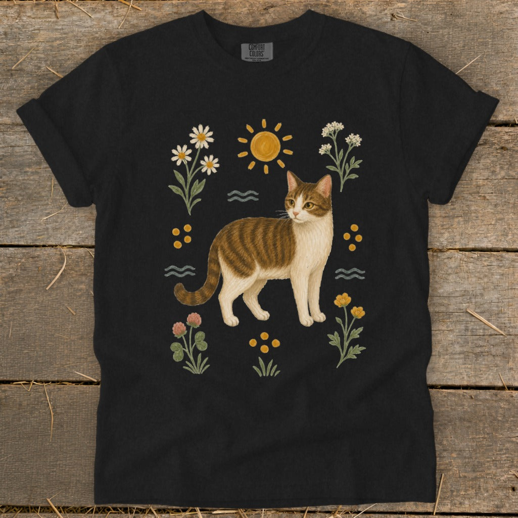 Black t-shirt featuring a tabby cat surrounded by wildflowers and a sun graphic.