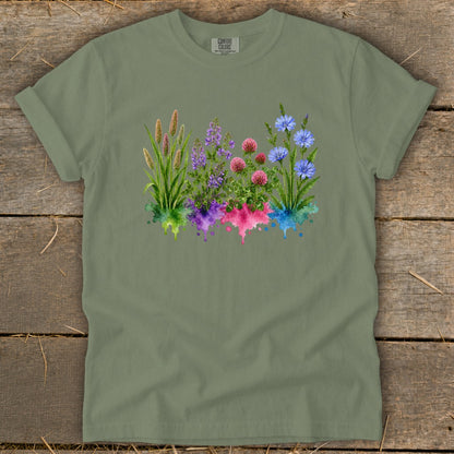 Sage green t-shirt featuring a watercolor graphic of four colorful wildflowers above matching paint splatters.