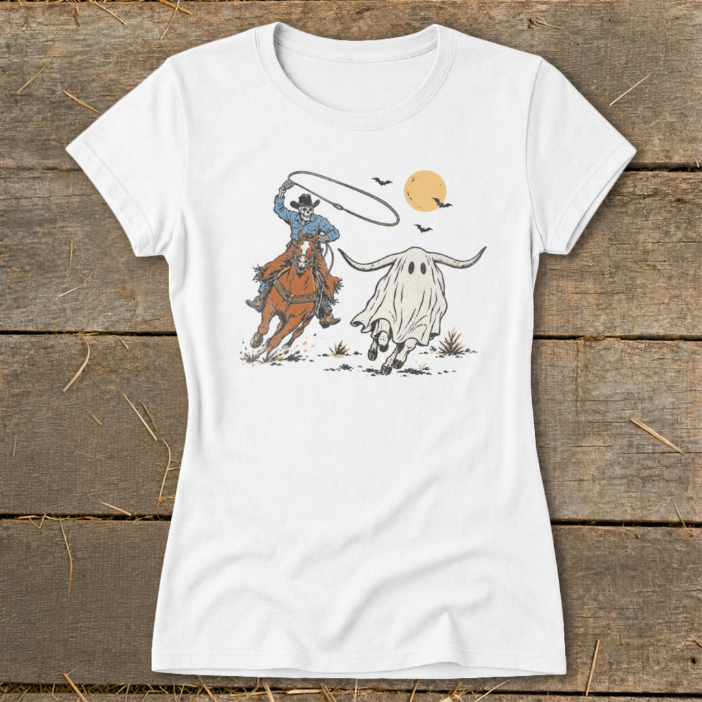 Skeleton cowboy on horseback lassos a ghost-shaped bull under a moonlit sky.