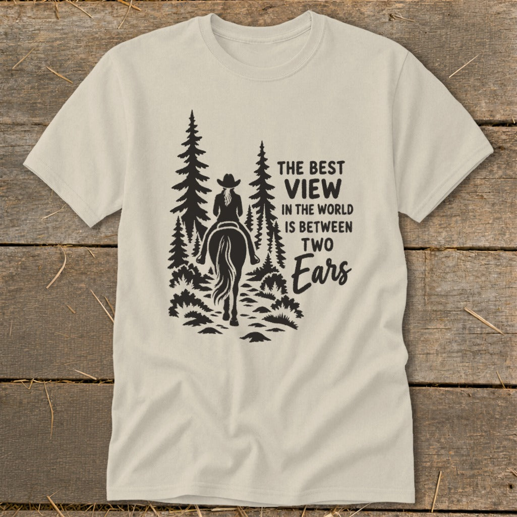 A light-colored t-shirt with a black graphic of a horseback rider in the woods and text.