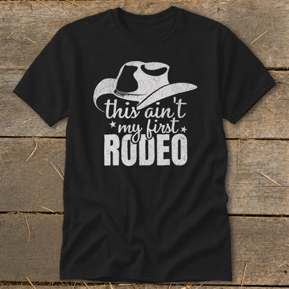 Black t-shirt with distressed cowboy hat graphic and "this ain't my first RODEO" text.