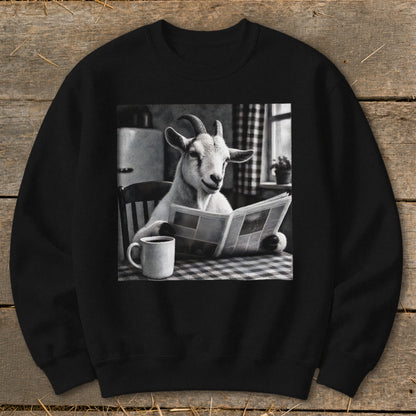 A black crewneck sweatshirt featuring a graphic of a goat sitting at a table, reading a newspaper next to a coffee mug.