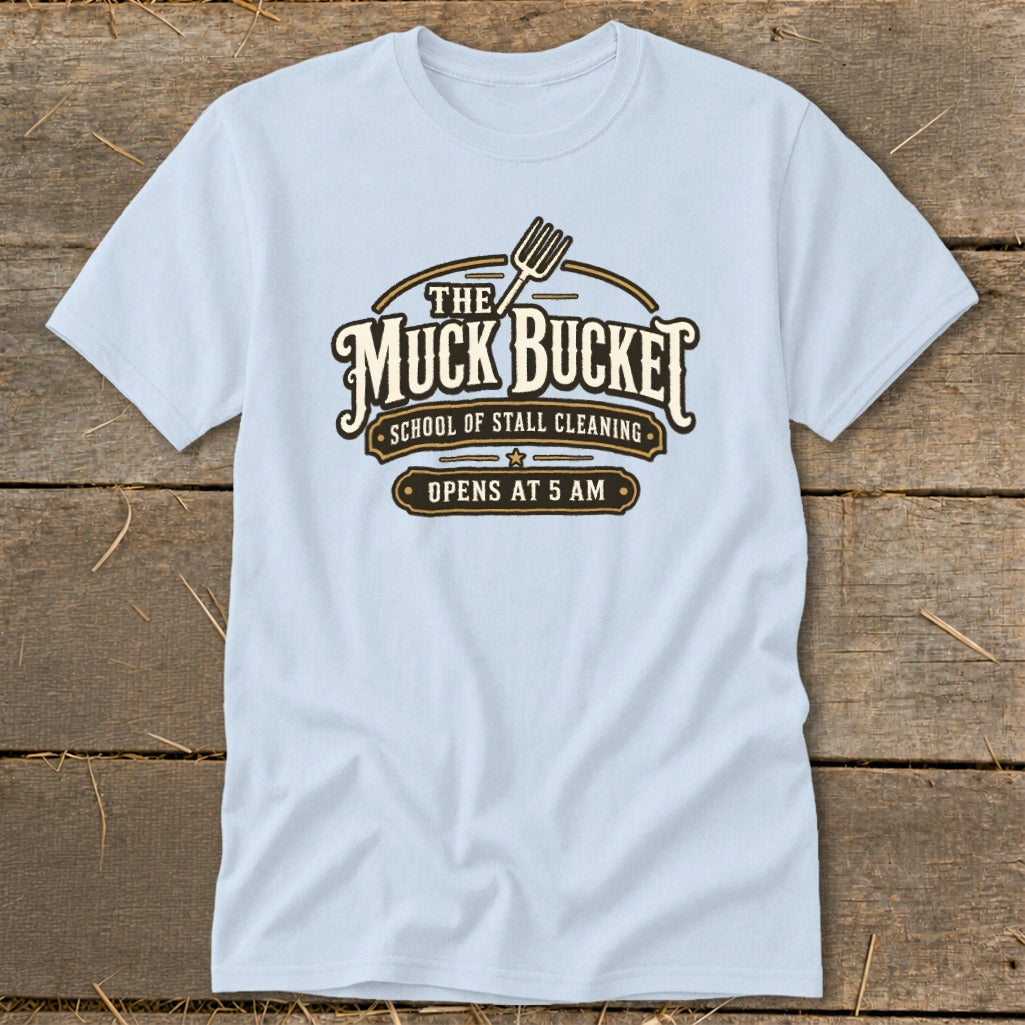 Light blue t-shirt with "The Muck Bucket School of Stall Cleaning Opens At 5 AM" text.