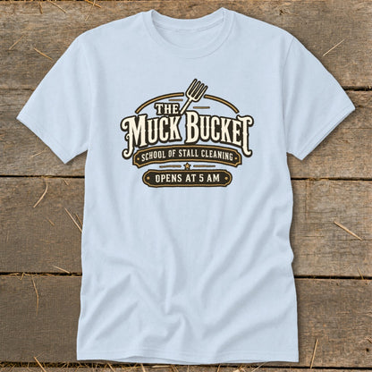 Light blue t-shirt with "The Muck Bucket School of Stall Cleaning Opens At 5 AM" text.