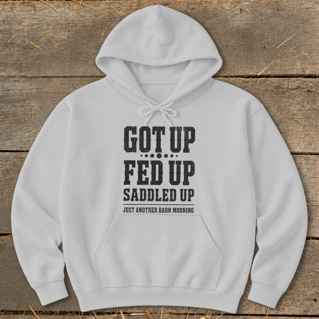 White hoodie with "Got Up, Fed Up, Saddled Up" text and "Just Another Barn Morning."
