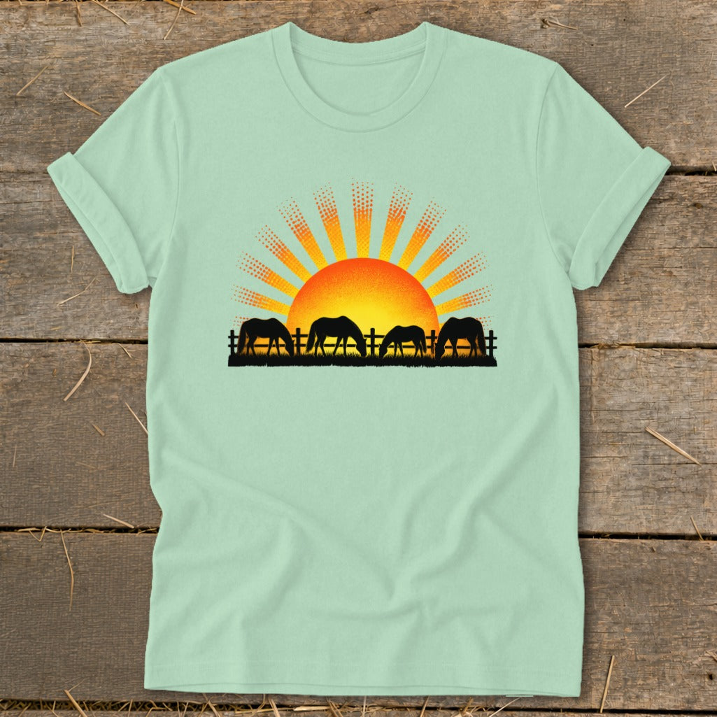 Mint t-shirt with horses grazing at sunrise graphic.