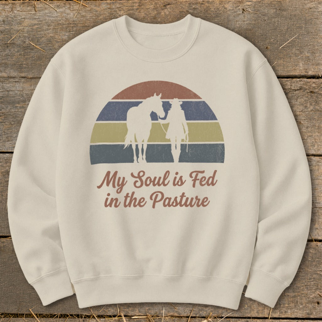 Cream sweatshirt with horse and rider silhouettes over a retro sunset and text.