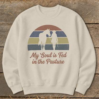 Cream sweatshirt with horse and rider silhouettes over a retro sunset and text.