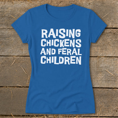 Blue t-shirt with white text reading "RAISING CHICKENS AND FERAL CHILDREN".