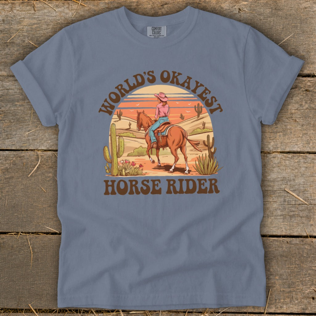 Graphic t-shirt with "World's Okayest Horse Rider" text and desert scene.