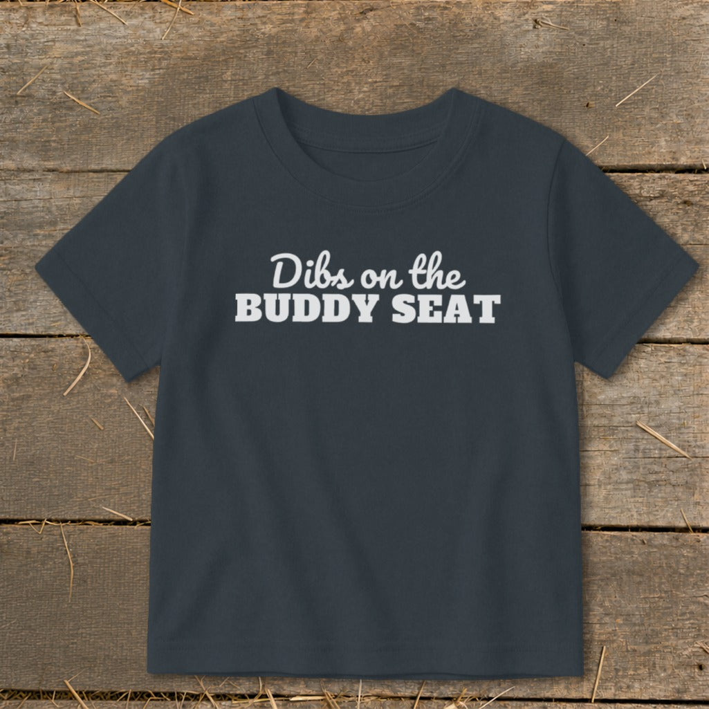 Dark grey t-shirt with "Dibs on the BUDDY SEAT" printed in white text.