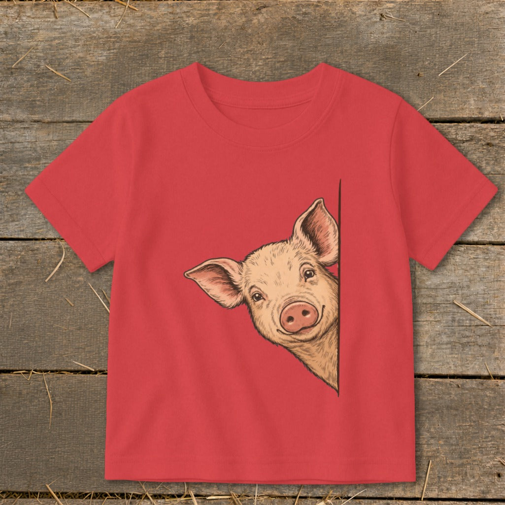 Red t-shirt with a drawing of a smiling pig peeking from the side.