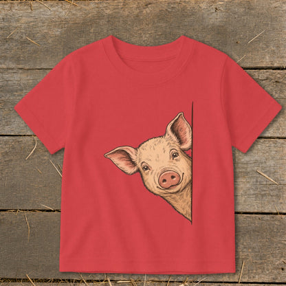 Red t-shirt with a drawing of a smiling pig peeking from the side.