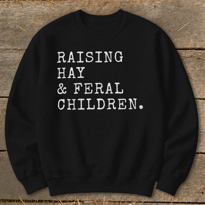 Black sweatshirt with white text: Raising Hay & Feral Children.