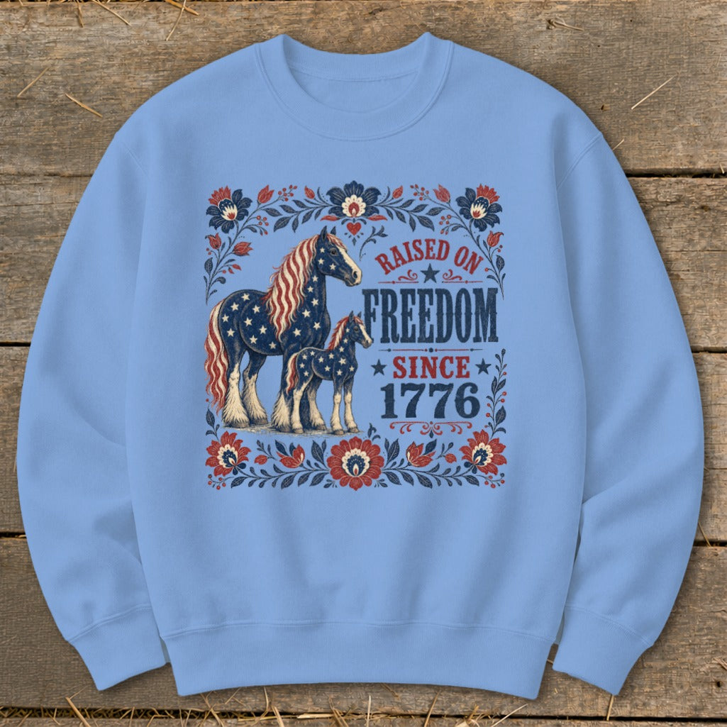 Light blue sweatshirt with horses and "Raised on Freedom Since 1776" text.