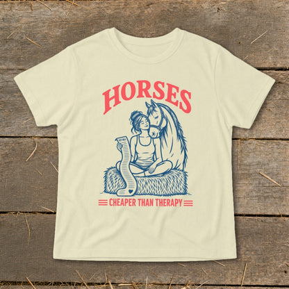 Cream t-shirt with "Horses Cheaper Than Therapy" graphic of a woman with a horse and a vet bill.