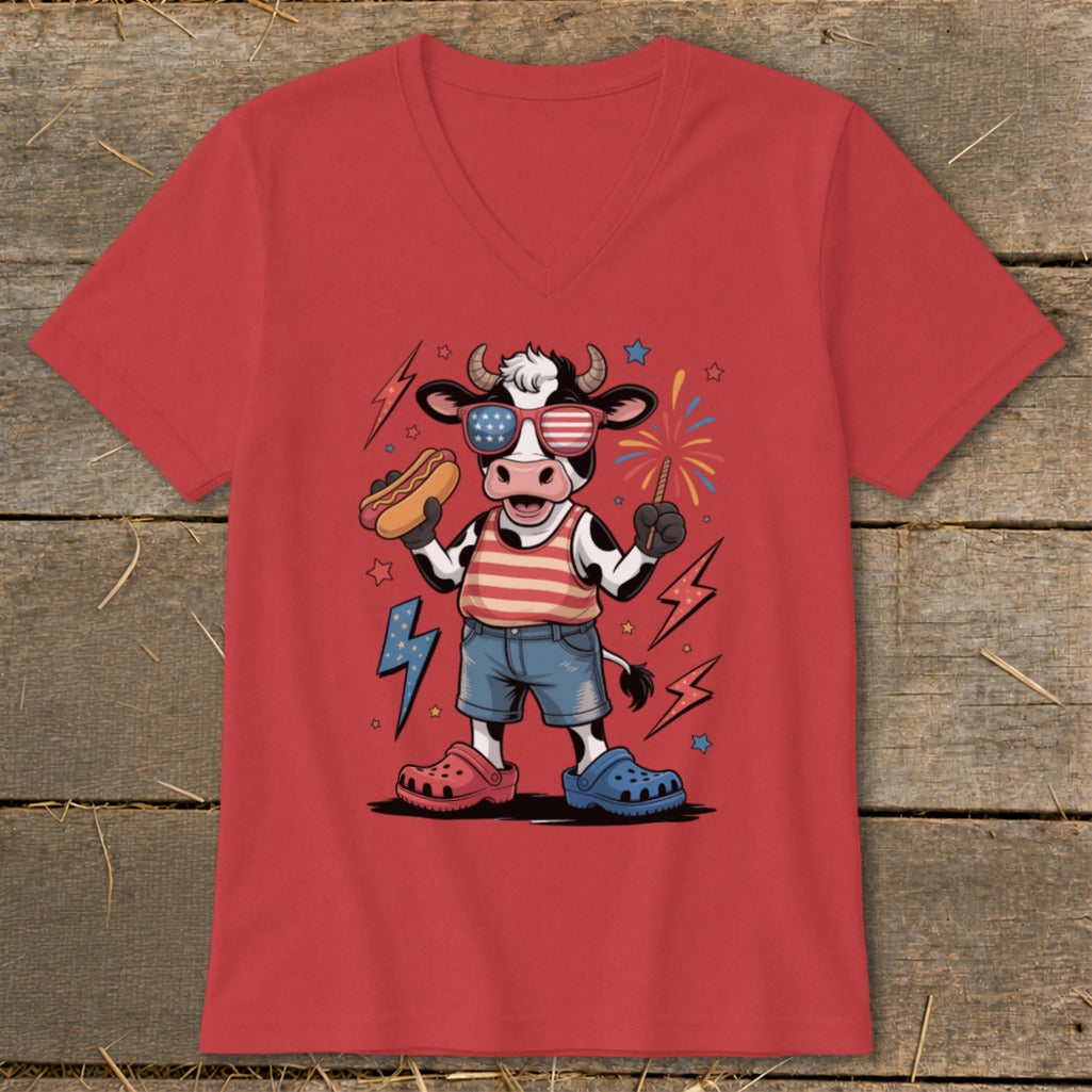 Cow wearing American flag sunglasses and shirt, holding a hot dog and sparkler.
