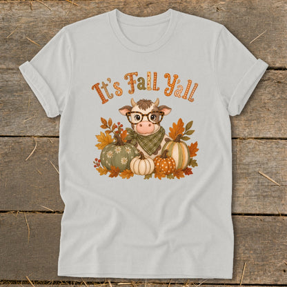 Light grey t-shirt with a cow wearing glasses and a bandana surrounded by pumpkins and fall leaves, with "It's Fall Y'all" text.