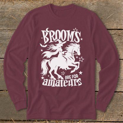 Maroon long-sleeve shirt with white graphic: witch riding horse, text "Brooms are for amateurs".