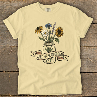 Pale yellow t-shirt with a mason jar of wildflowers and the text "WILD AND BARN GROWN".