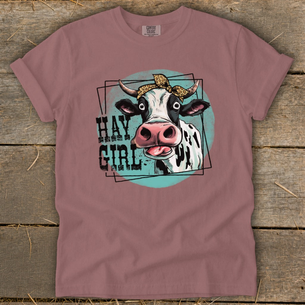 Cow with leopard print bandana and text "HAY GIRL" on a t-shirt.