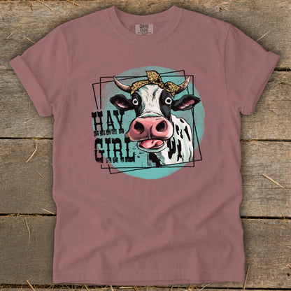 Cow with leopard print bandana and text "HAY GIRL" on a t-shirt.