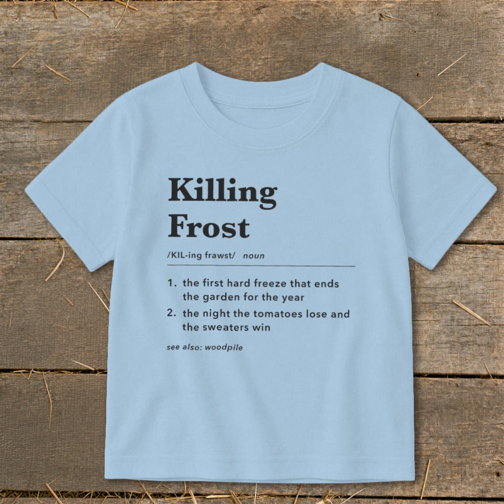 Light blue t-shirt featuring dictionary-style text defining Killing Frost on a wooden surface.