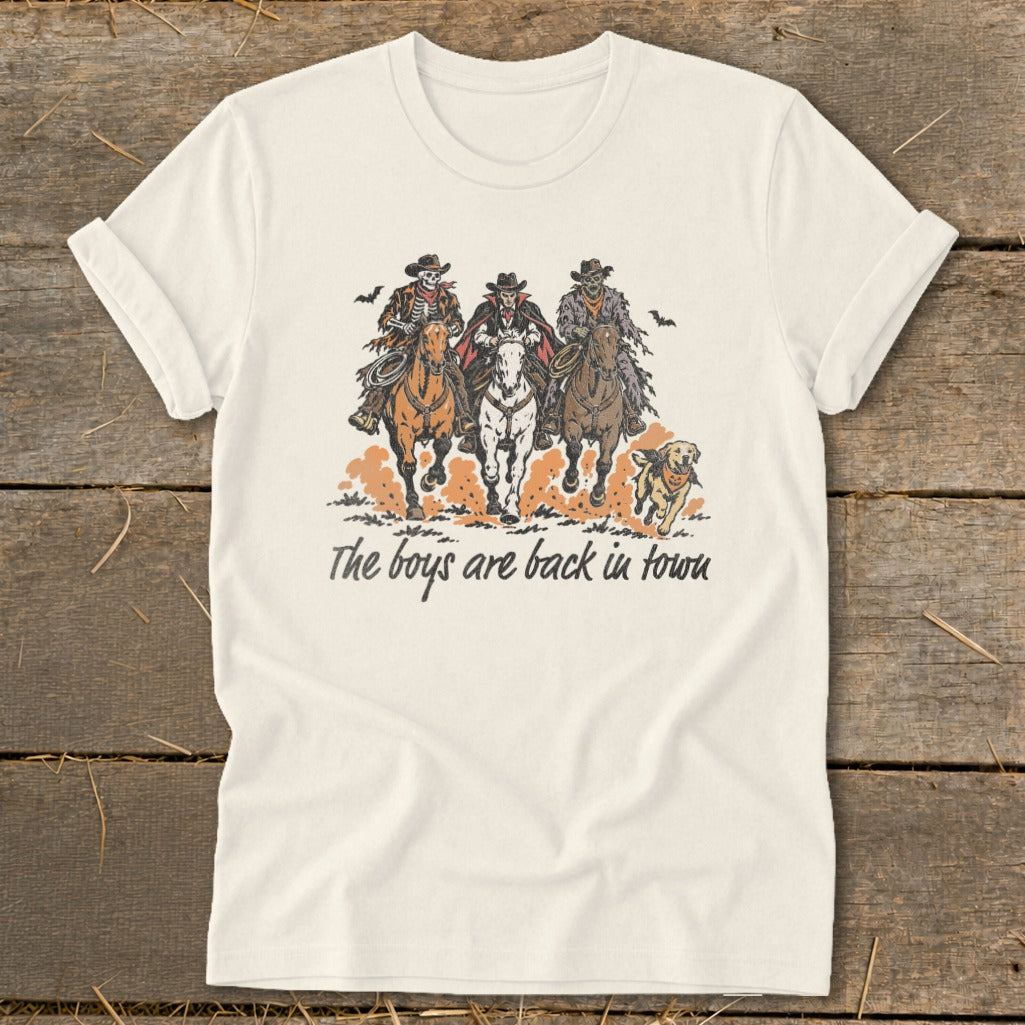 T-shirt with graphic of three skeleton cowboys on horseback, a dog, and text.