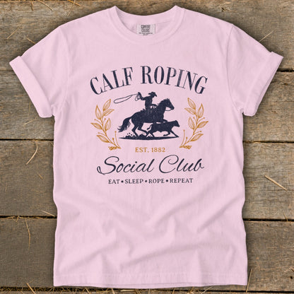 Pink t-shirt with Calf Roping Social Club graphic, featuring a rider, horse, and calf.
