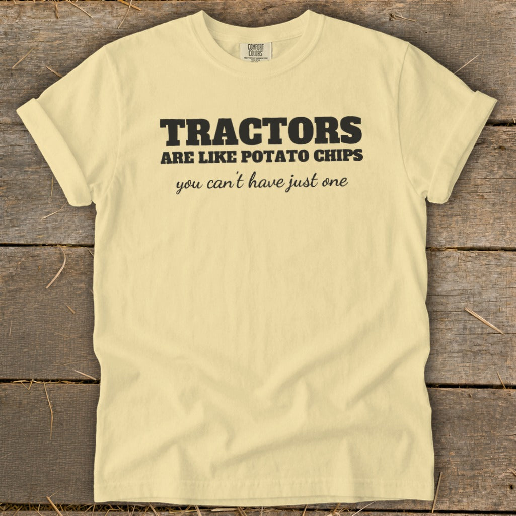 Yellow t-shirt with black text reading "TRACTORS ARE LIKE POTATO CHIPS you can't have just one".