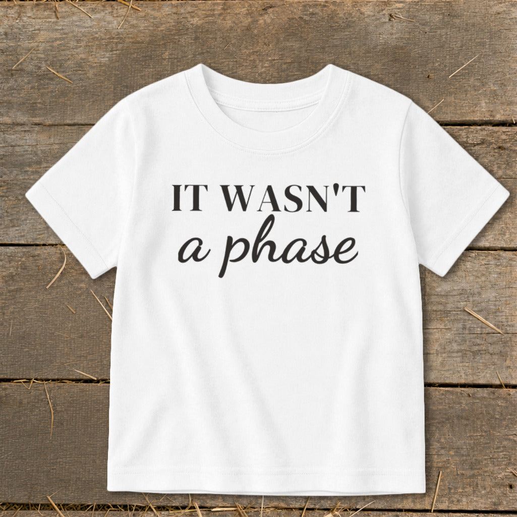 White t-shirt with black text that reads "IT WASN'T a phase".