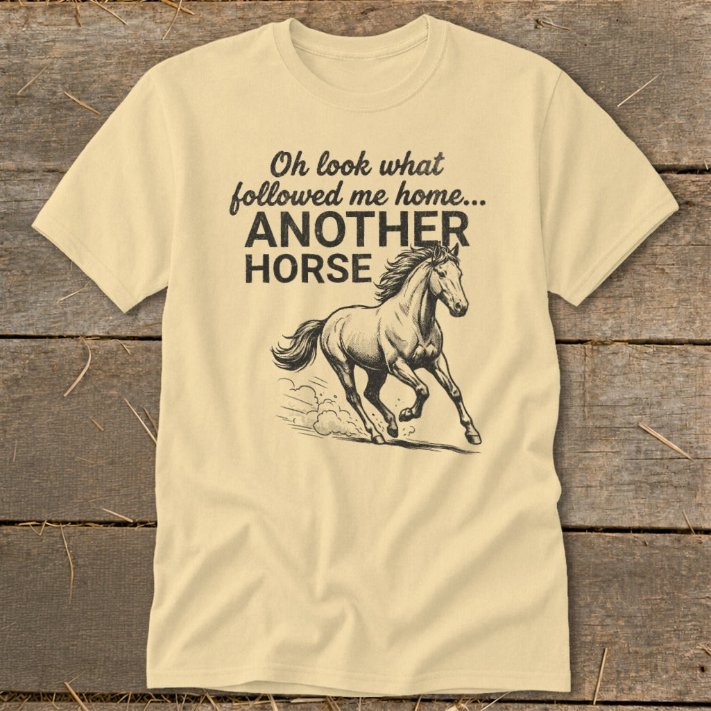 Light yellow t-shirt with text "Oh look what followed me home... ANOTHER HORSE" and running horse graphic.
