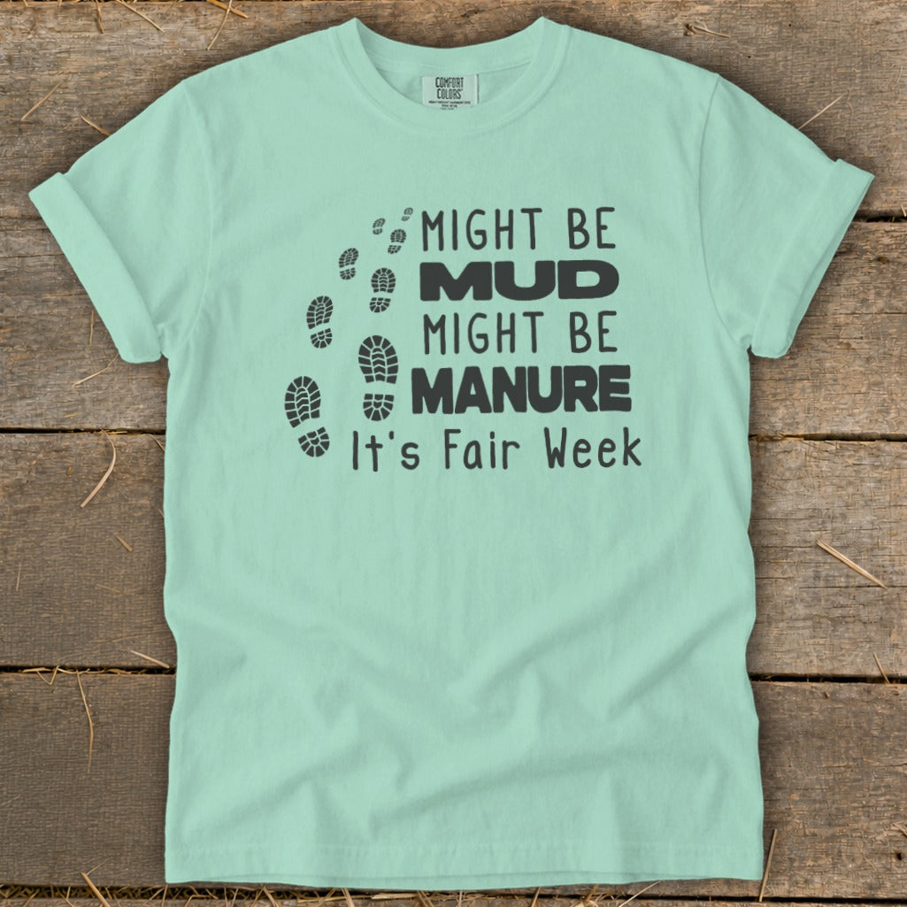 Mint t-shirt with "Might Be Mud, Might Be Manure, It's Fair Week" text and footprints.