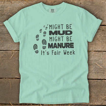 Mint t-shirt with "Might Be Mud, Might Be Manure, It's Fair Week" text and footprints.