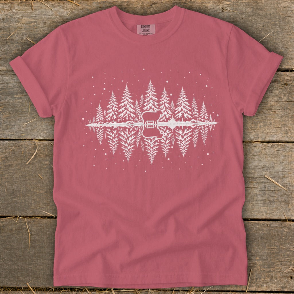 Pink t-shirt with white pine trees and a guitar reflected in water.
