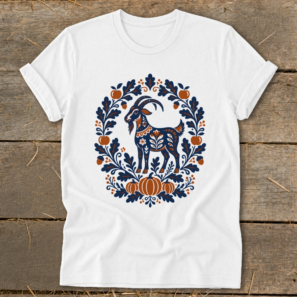 White short-sleeve t-shirt featuring a folk art illustration of a goat surrounded by leaves, acorns, and pumpkins.