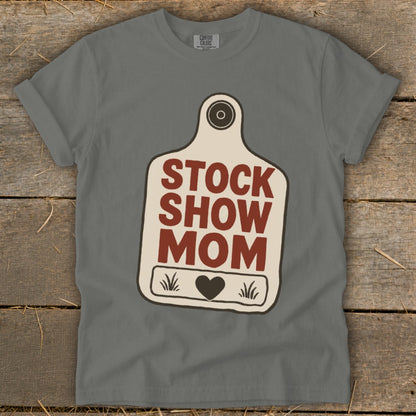 Grey t-shirt with "STOCK SHOW MOM" text and a heart on a tag graphic.