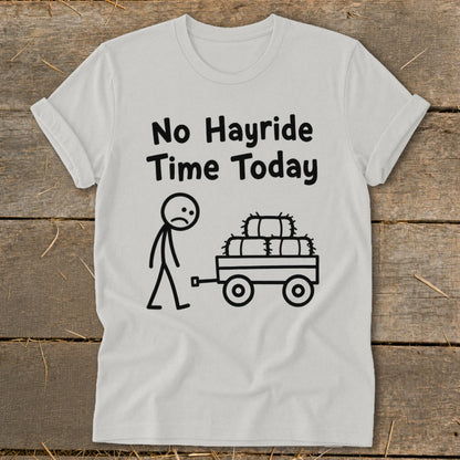 White t-shirt with black text and illustration of a sad stick figure and hay bales on a wagon.