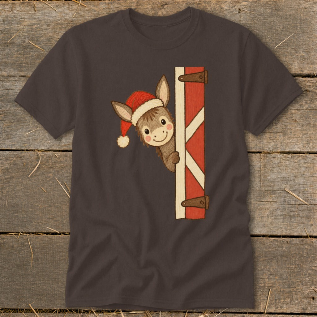 Donkey wearing Santa hat peeking around barn door on dark gray t-shirt.